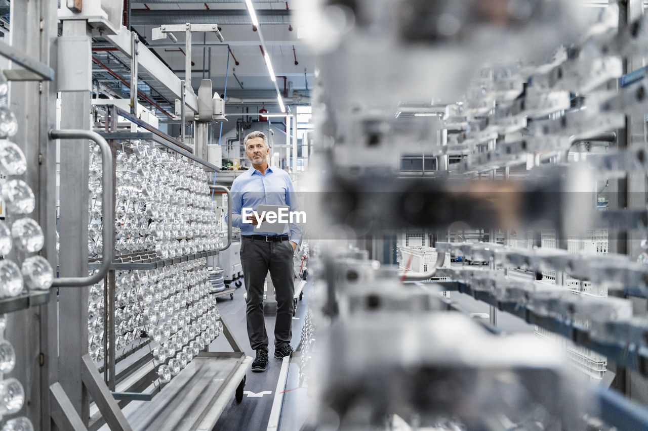 Businessman checking production line at automated industry