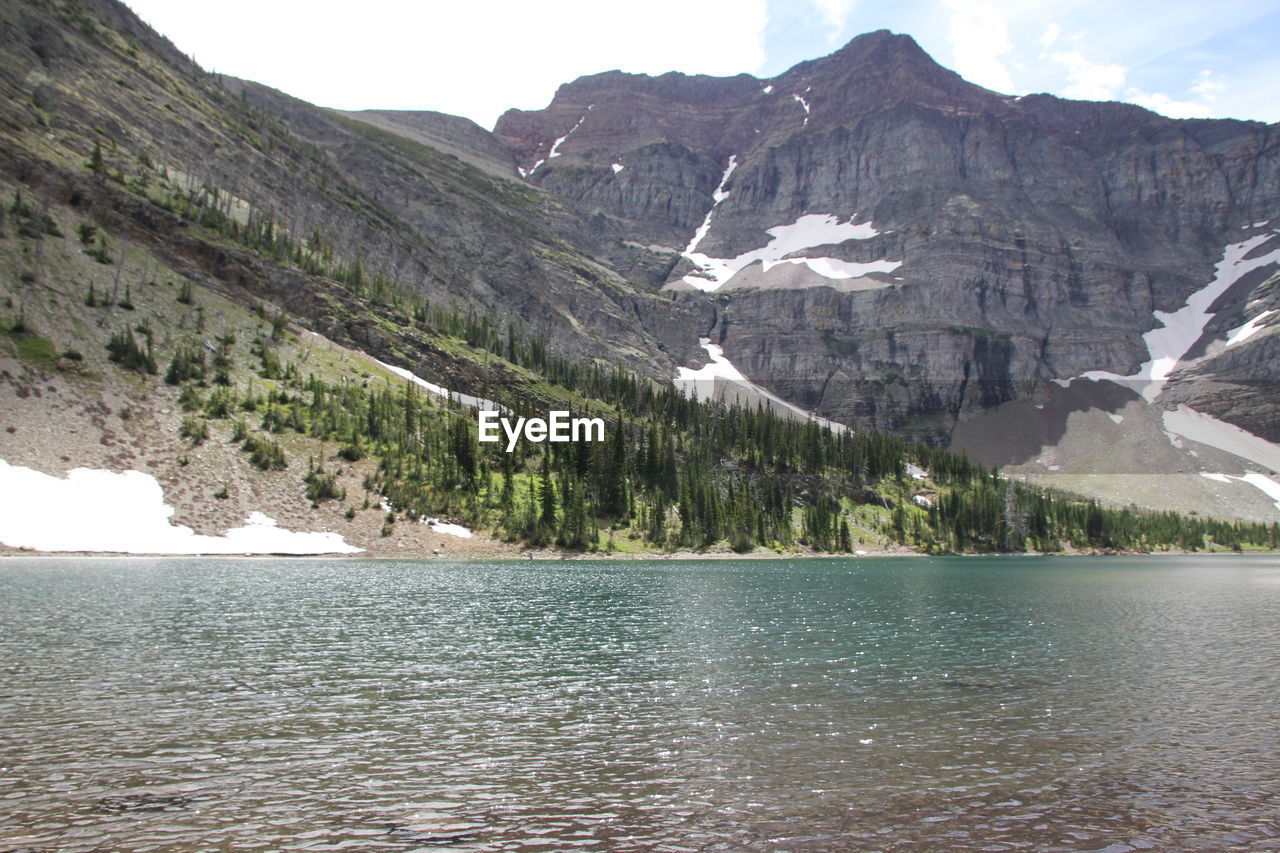 Scenic view of rocky mountains by lake during winter