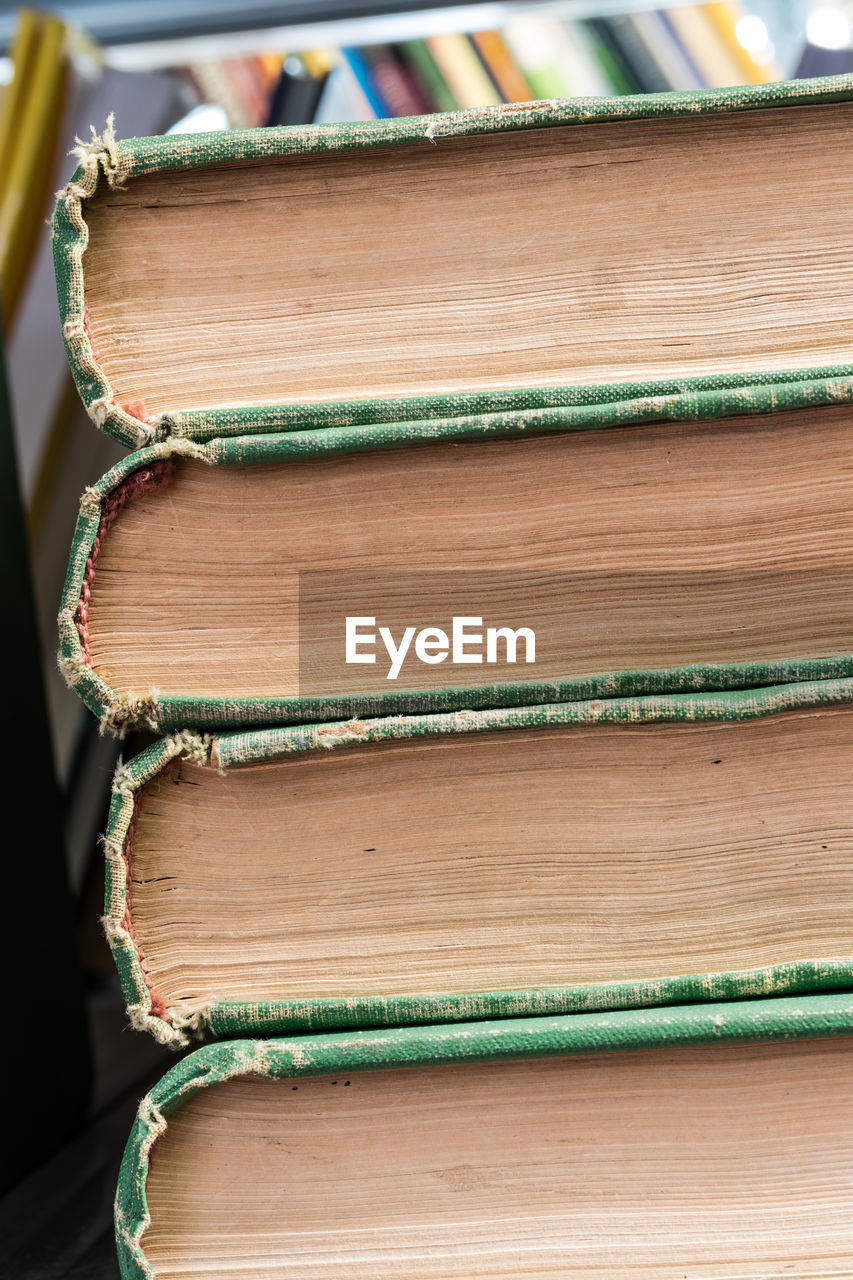 CLOSE-UP OF OLD BOOKS ON TABLE