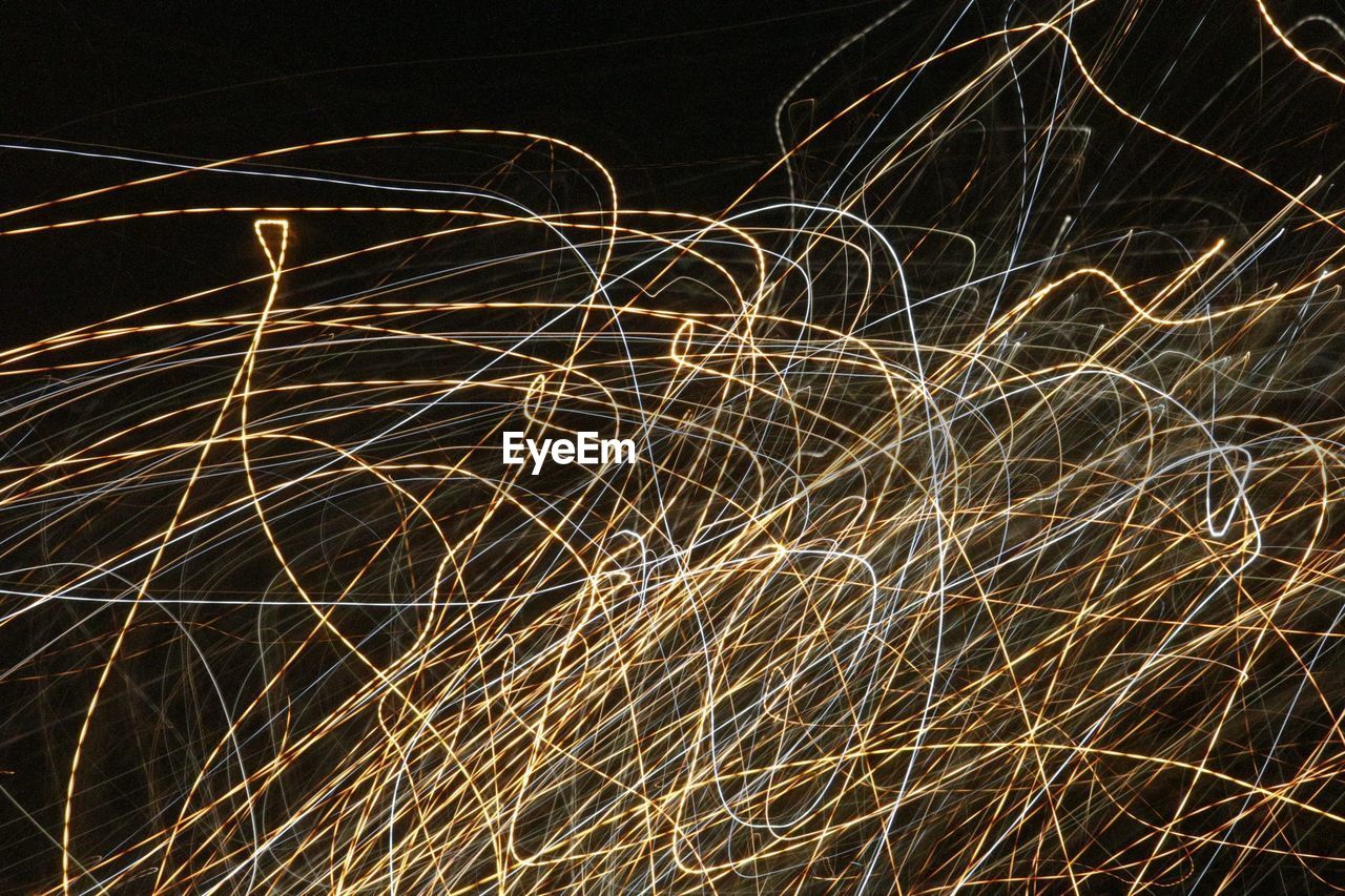 CLOSE-UP OF LIGHT TRAILS AGAINST SKY