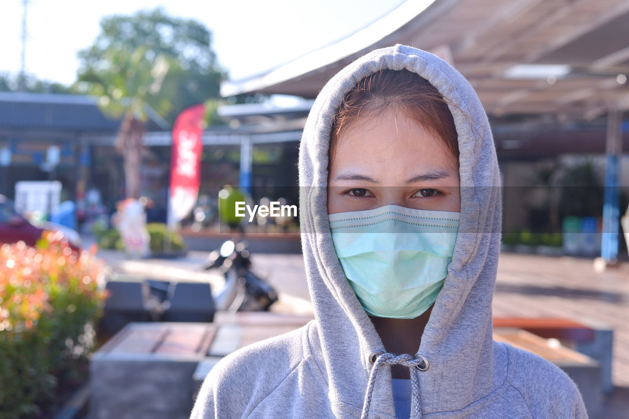 A young woman protecting herself from the covid-19 pandemic  by wearing a mask and social distance