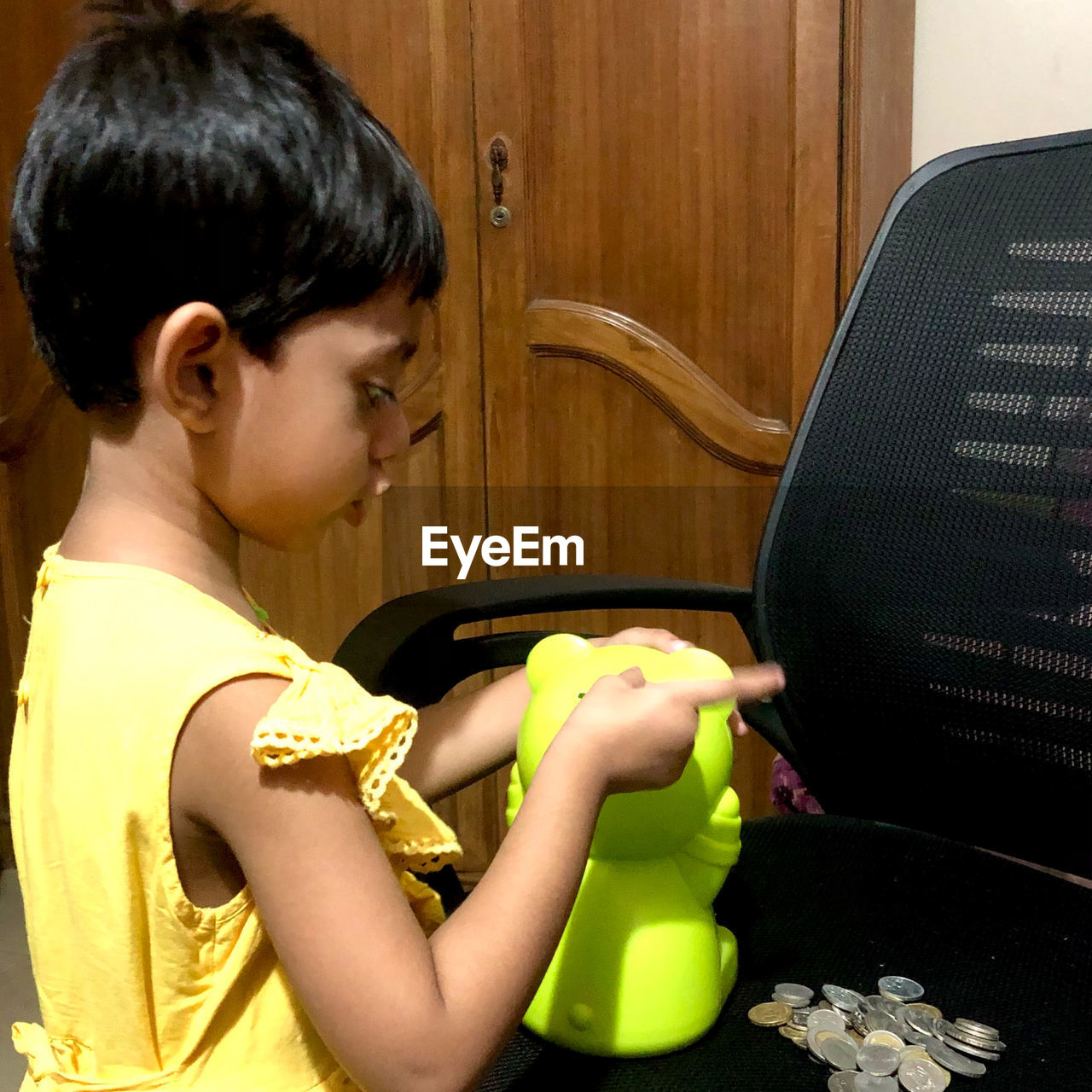 SIDE VIEW PORTRAIT OF BOY SITTING AT TABLE AT HOME