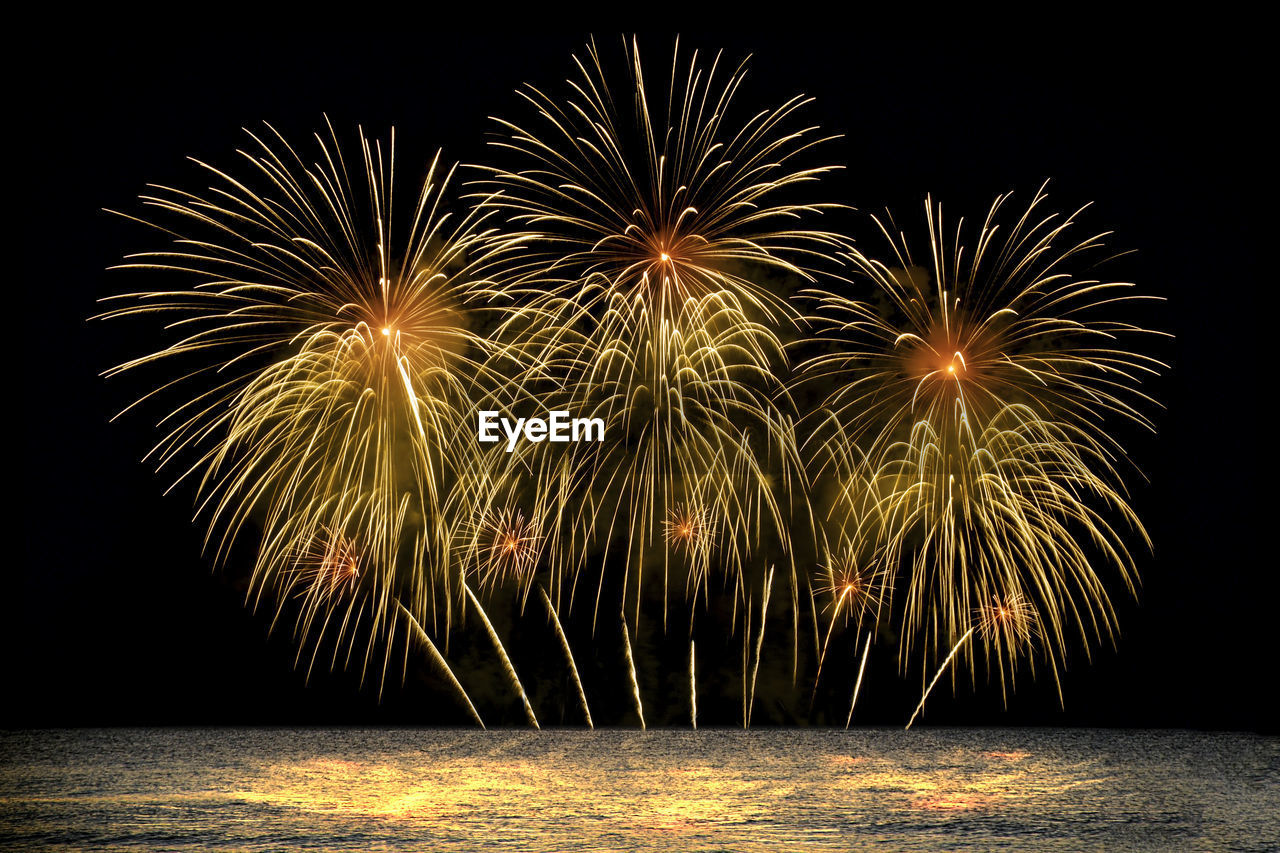 Colorful fireworks celebration from the sea with the midnight sky background.