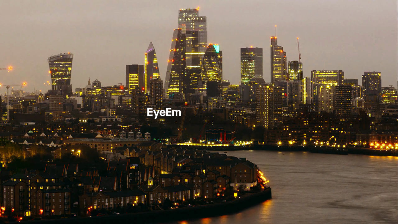 Illuminated buildings in city against sky at night