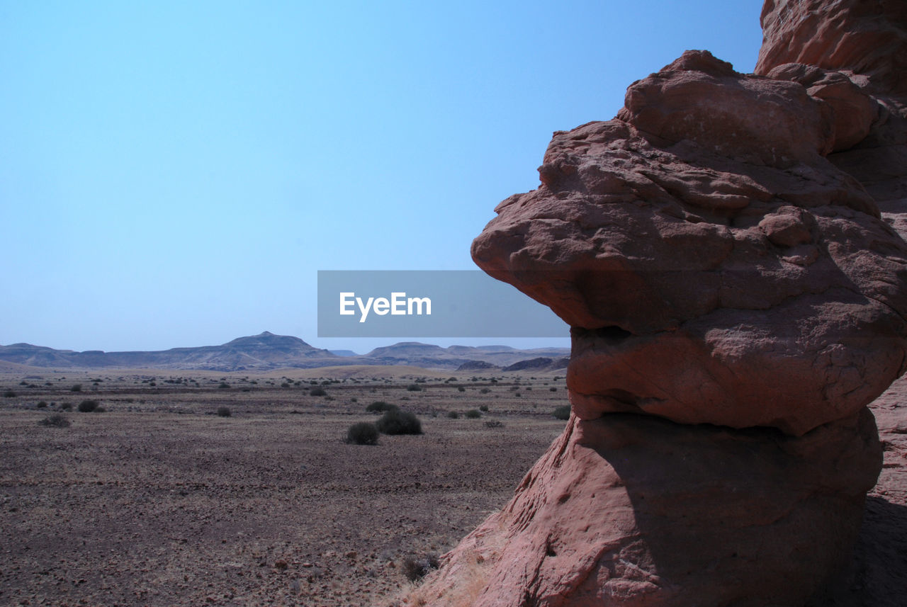 Close-up of rock formation in desert against clear sky