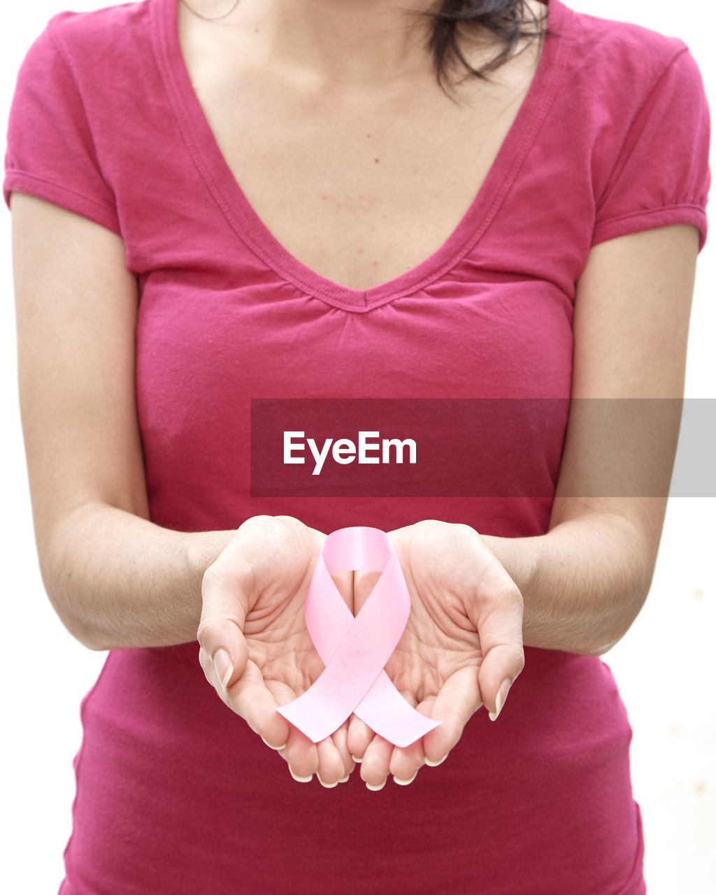 Woman holding pink breast cancer awareness ribbon against white background