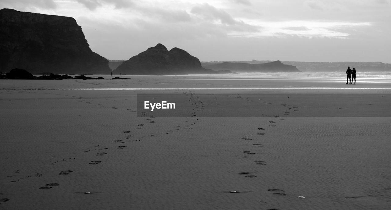 SCENIC VIEW OF BEACH BY MOUNTAINS AGAINST SKY