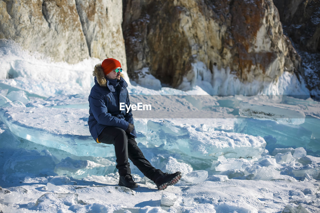 low angle view of man standing on snow covered mountain