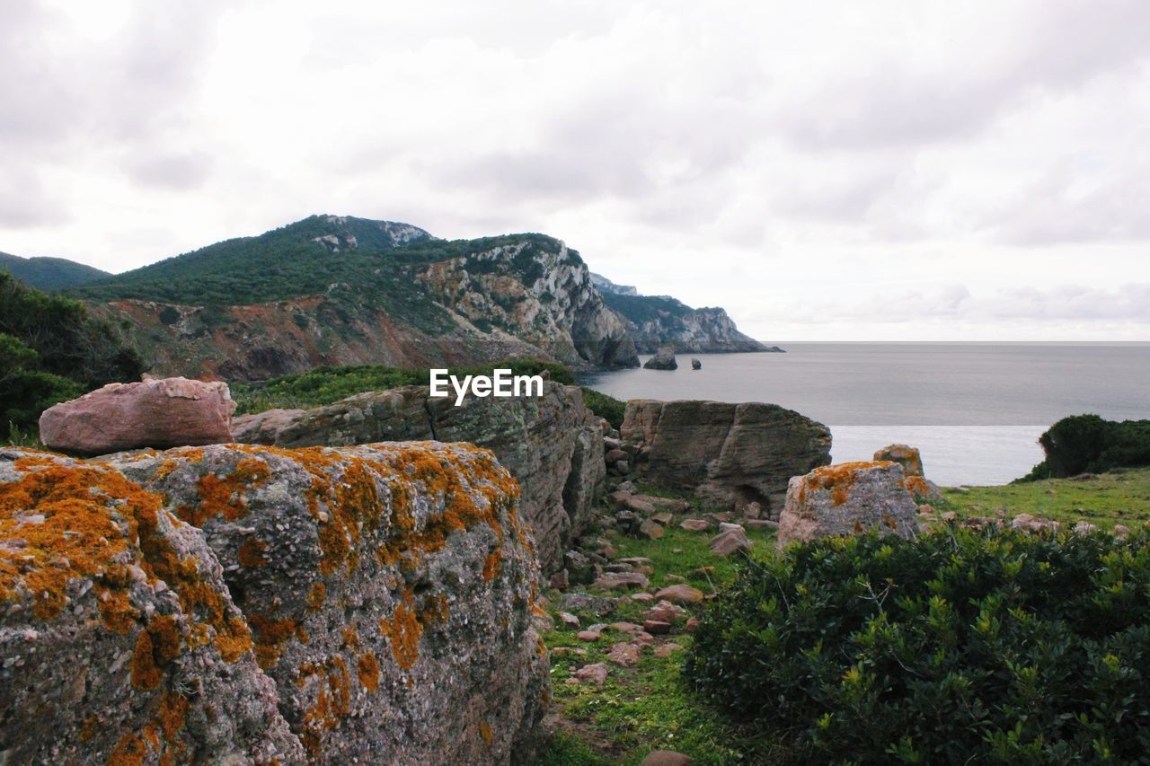 SCENIC VIEW OF SEA BY ROCK FORMATION AGAINST SKY