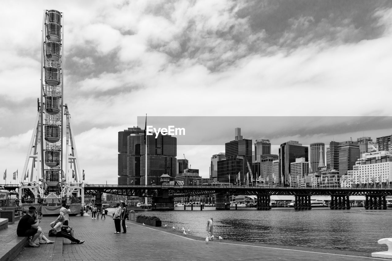 City at waterfront against cloudy sky