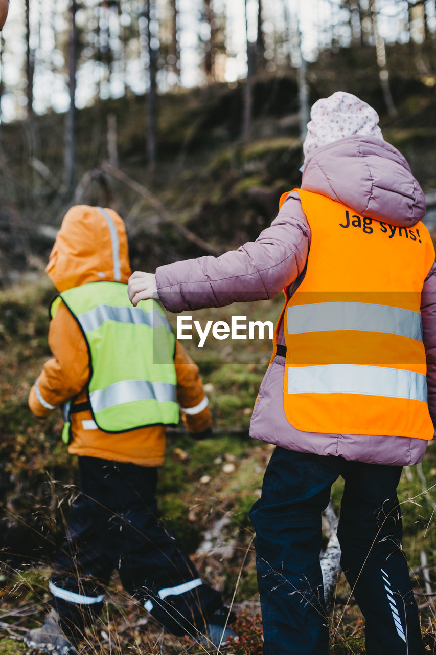 Rear view of children wearing reflective vests