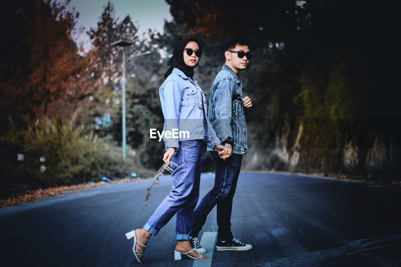 PORTRAIT OF YOUNG COUPLE ON ROAD