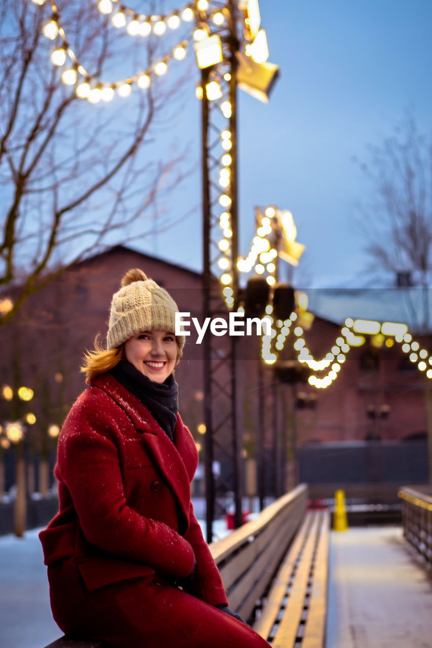 Portrait of smiling woman in city during winter