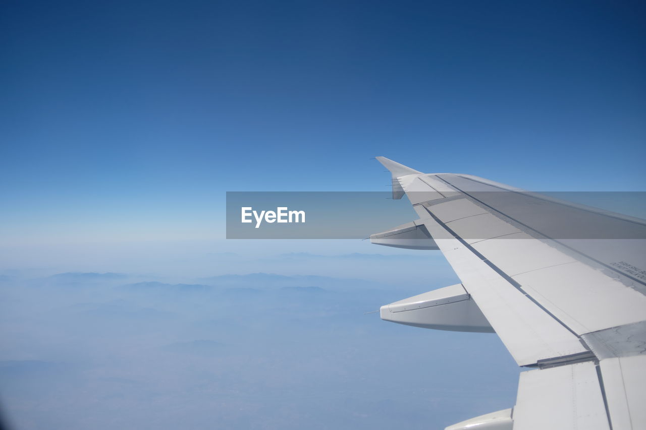 Cropped airplane flying over blue sky