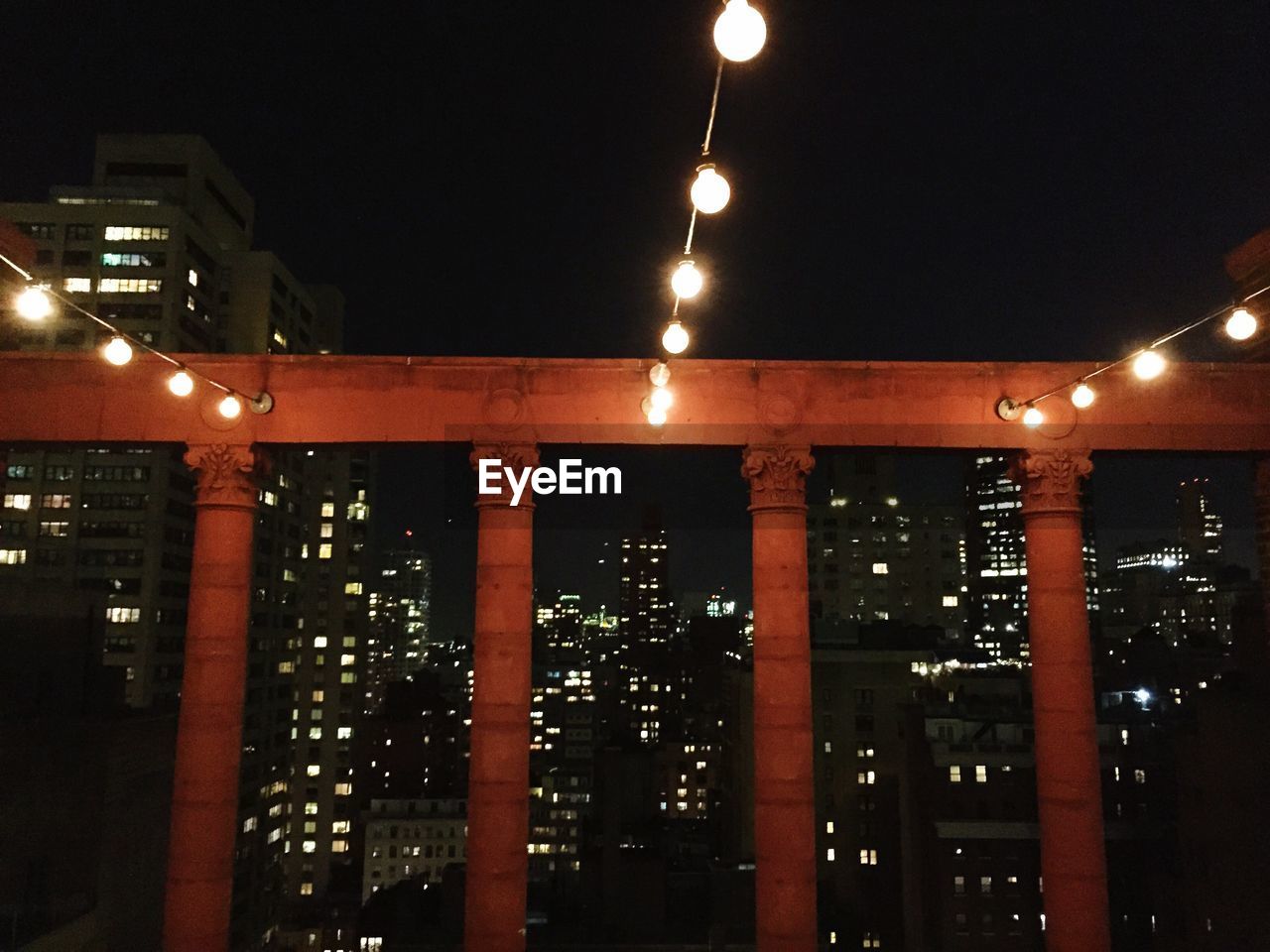 Illuminated buildings in city against sky at night