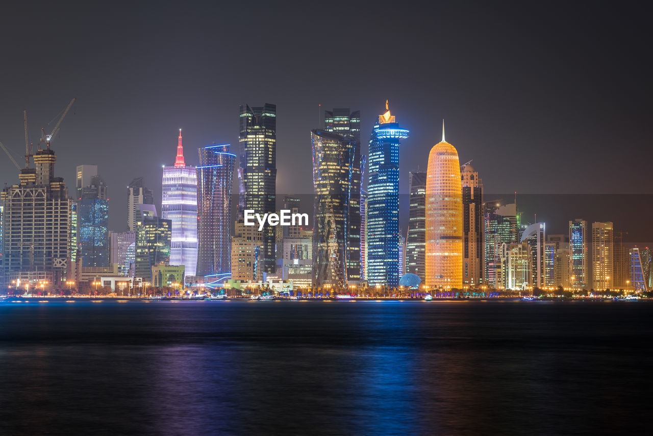 Illuminated buildings against sky at night