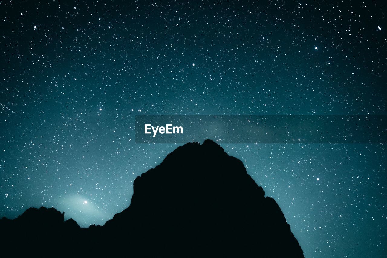 LOW ANGLE VIEW OF SILHOUETTE MAN AGAINST SKY AT NIGHT