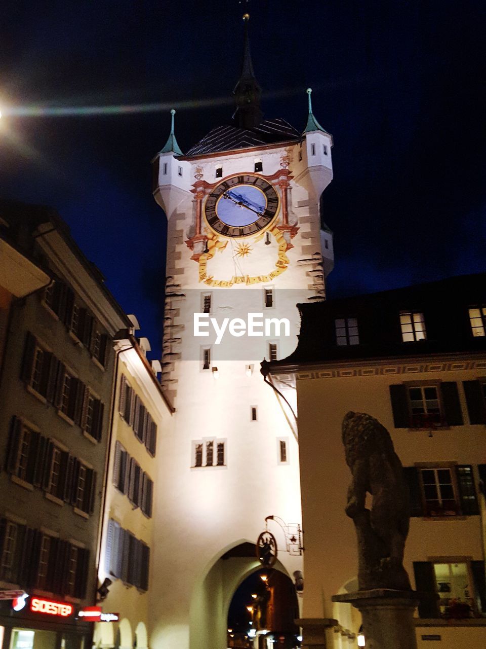 LOW ANGLE VIEW OF CLOCK TOWER AMIDST BUILDINGS IN CITY