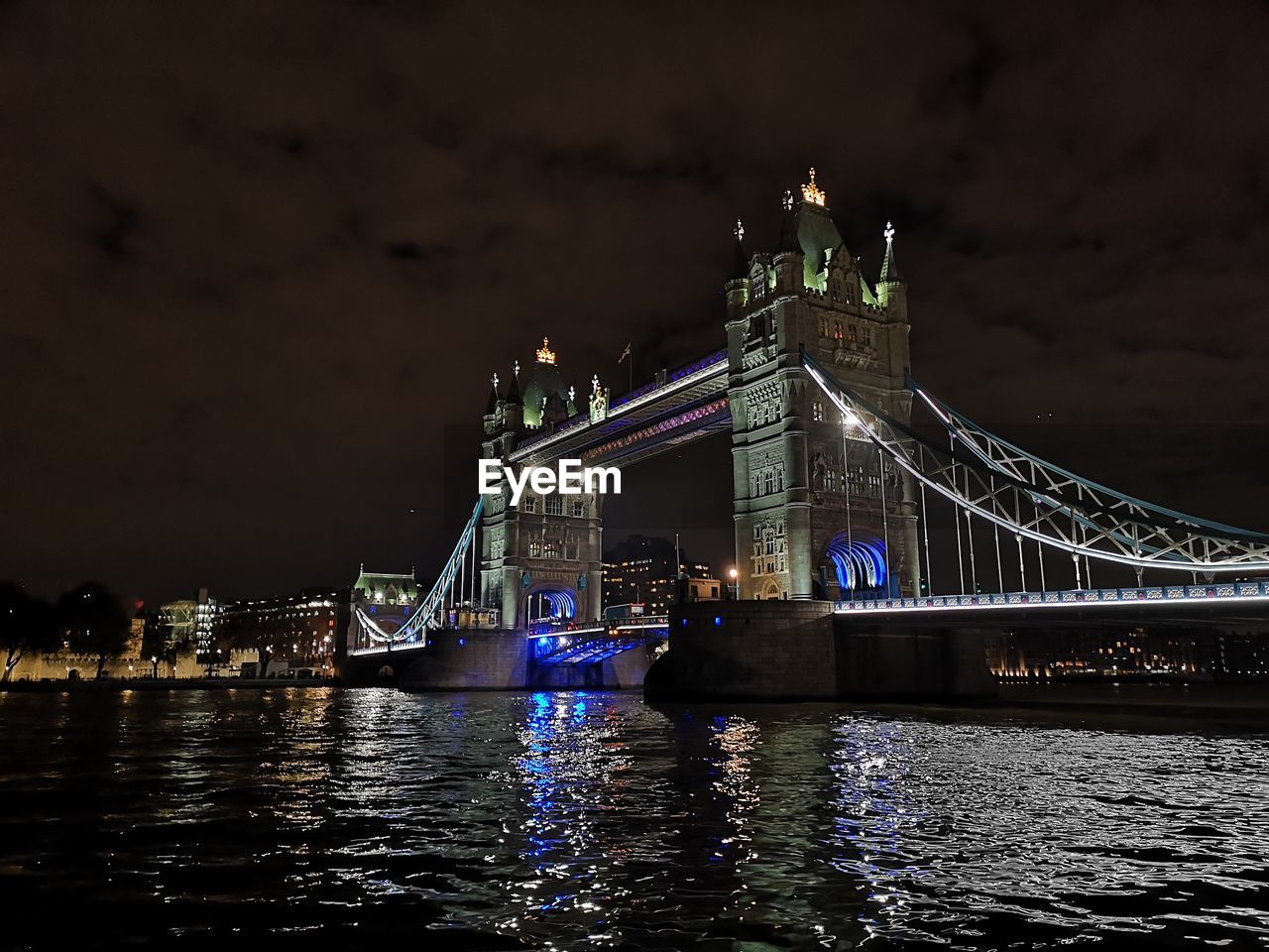 ILLUMINATED BRIDGE OVER RIVER IN CITY