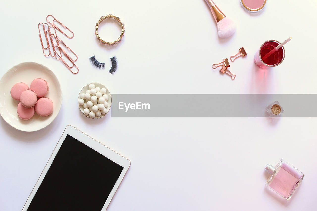 High angle view of personal accessories with food and drink on white background