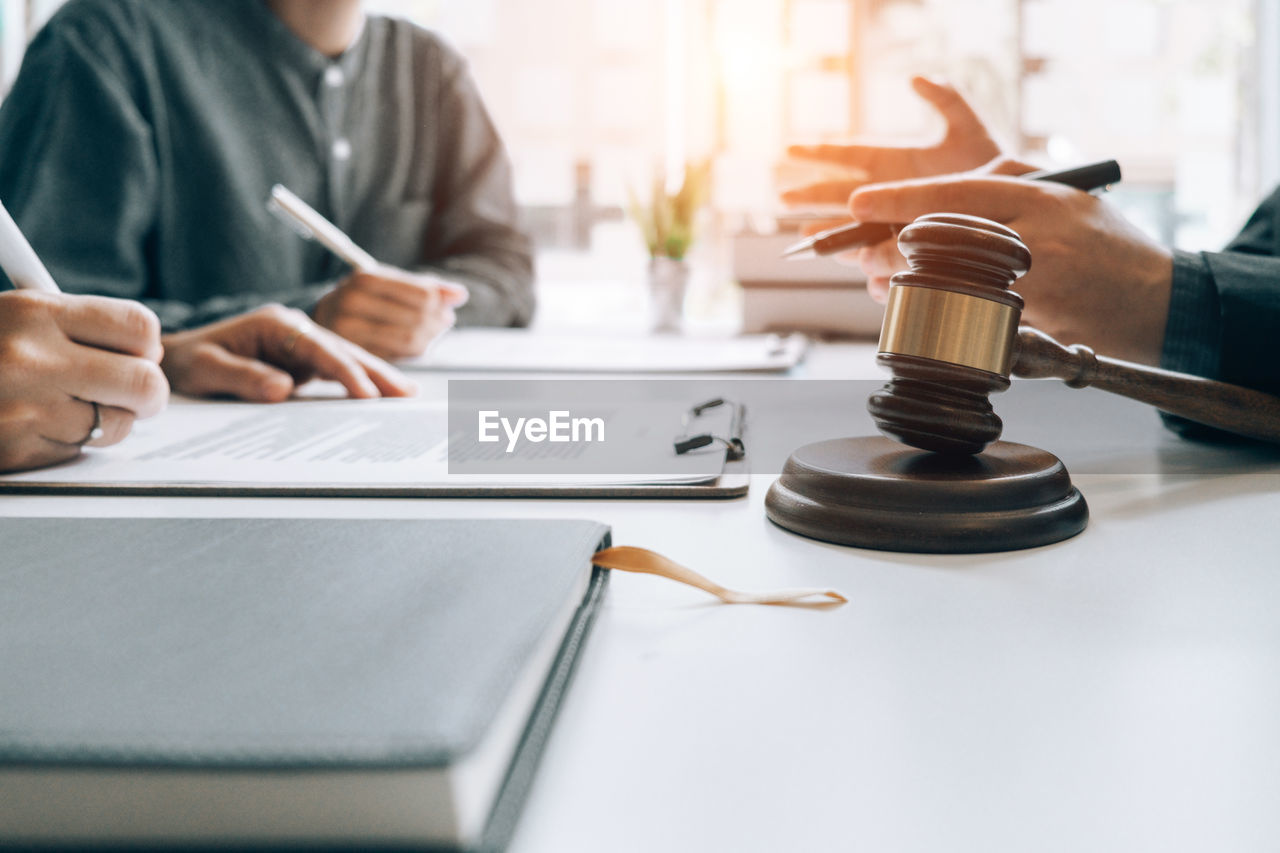 Cropped hands of lawyer gesturing while sitting at desk