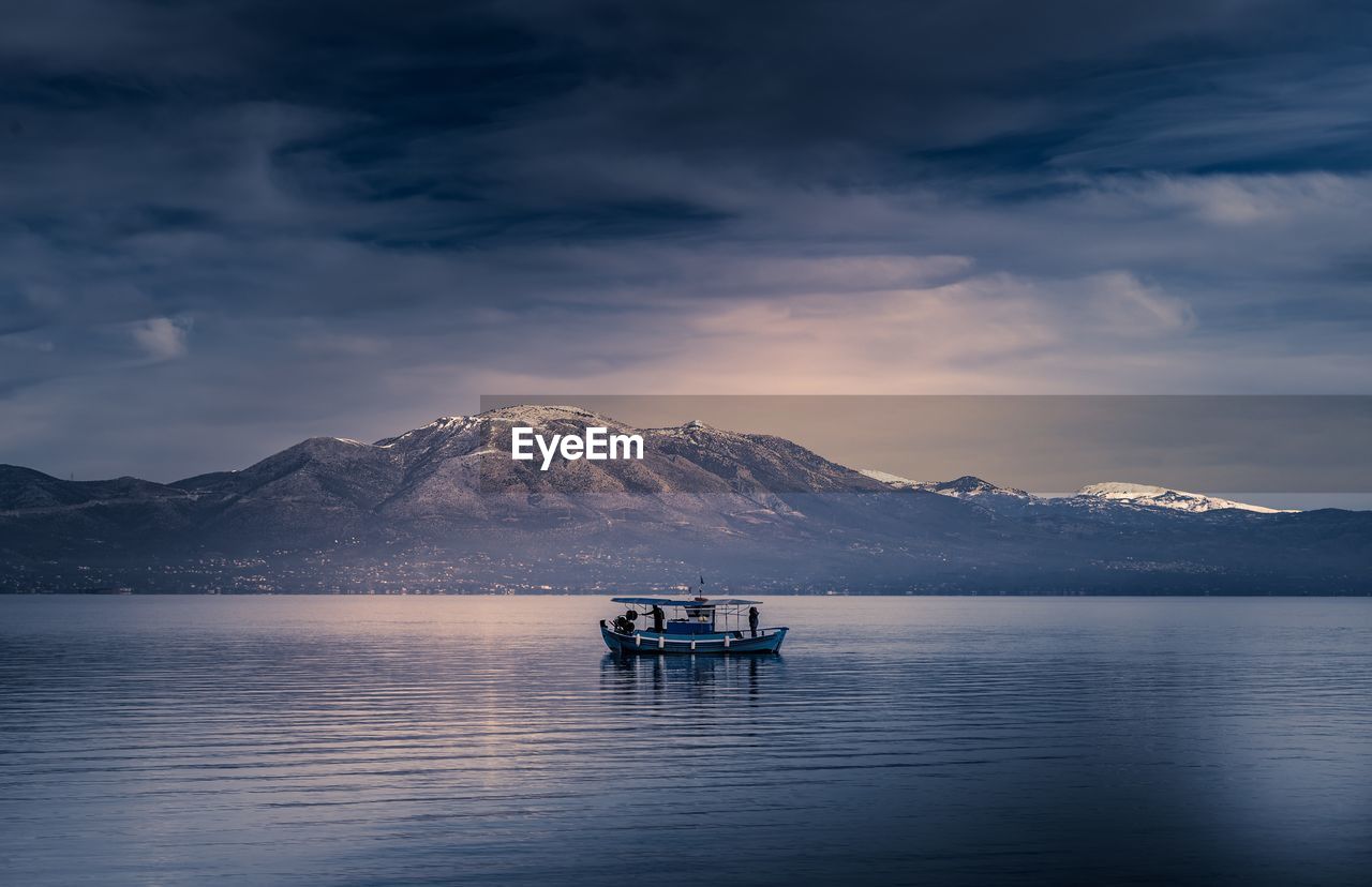 Boat in lake against mountains and sky