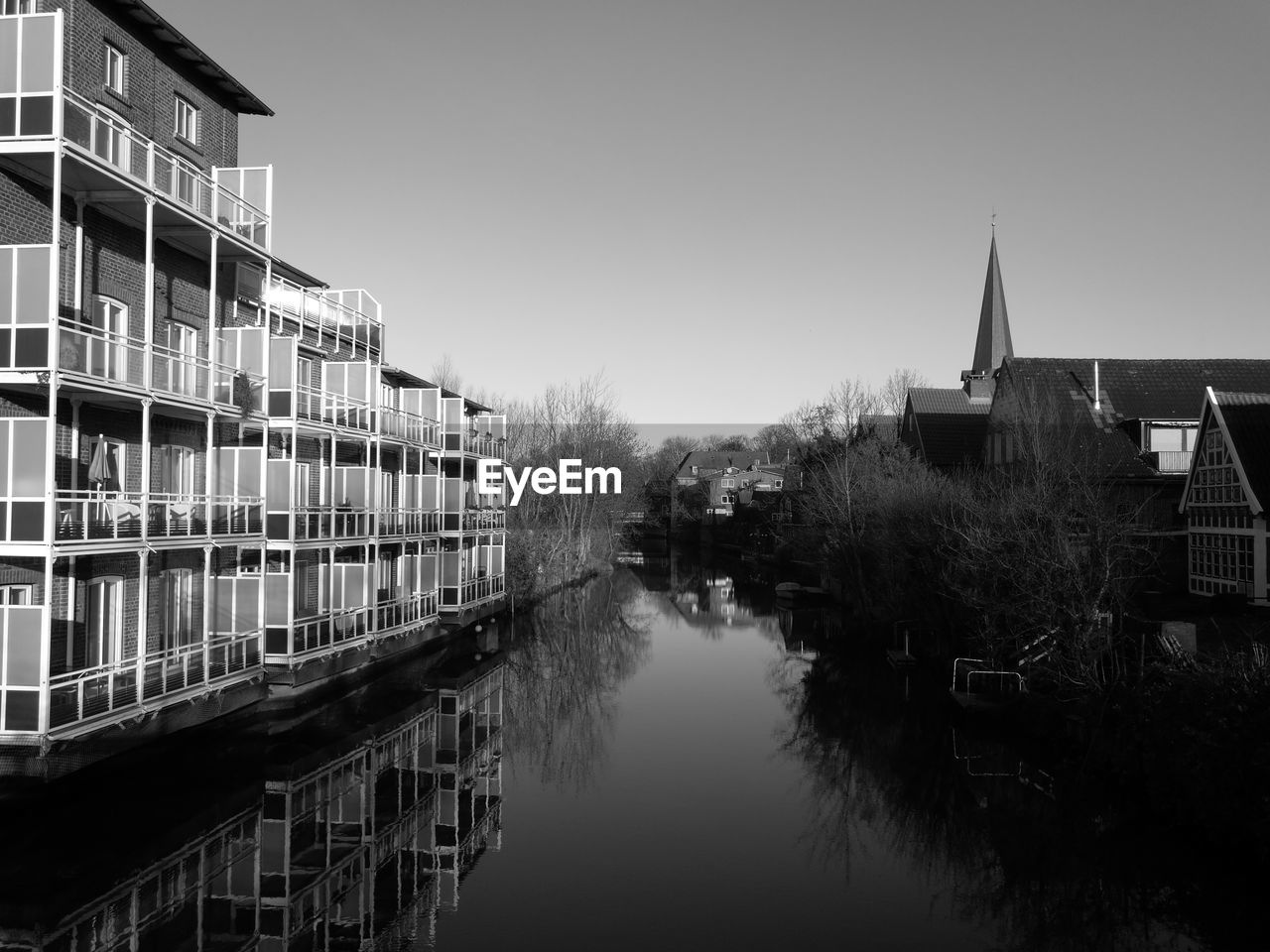 RIVER BY BUILDINGS AGAINST SKY