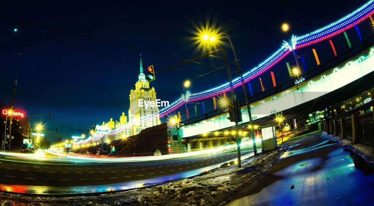 SUSPENSION BRIDGE OVER RIVER AT NIGHT