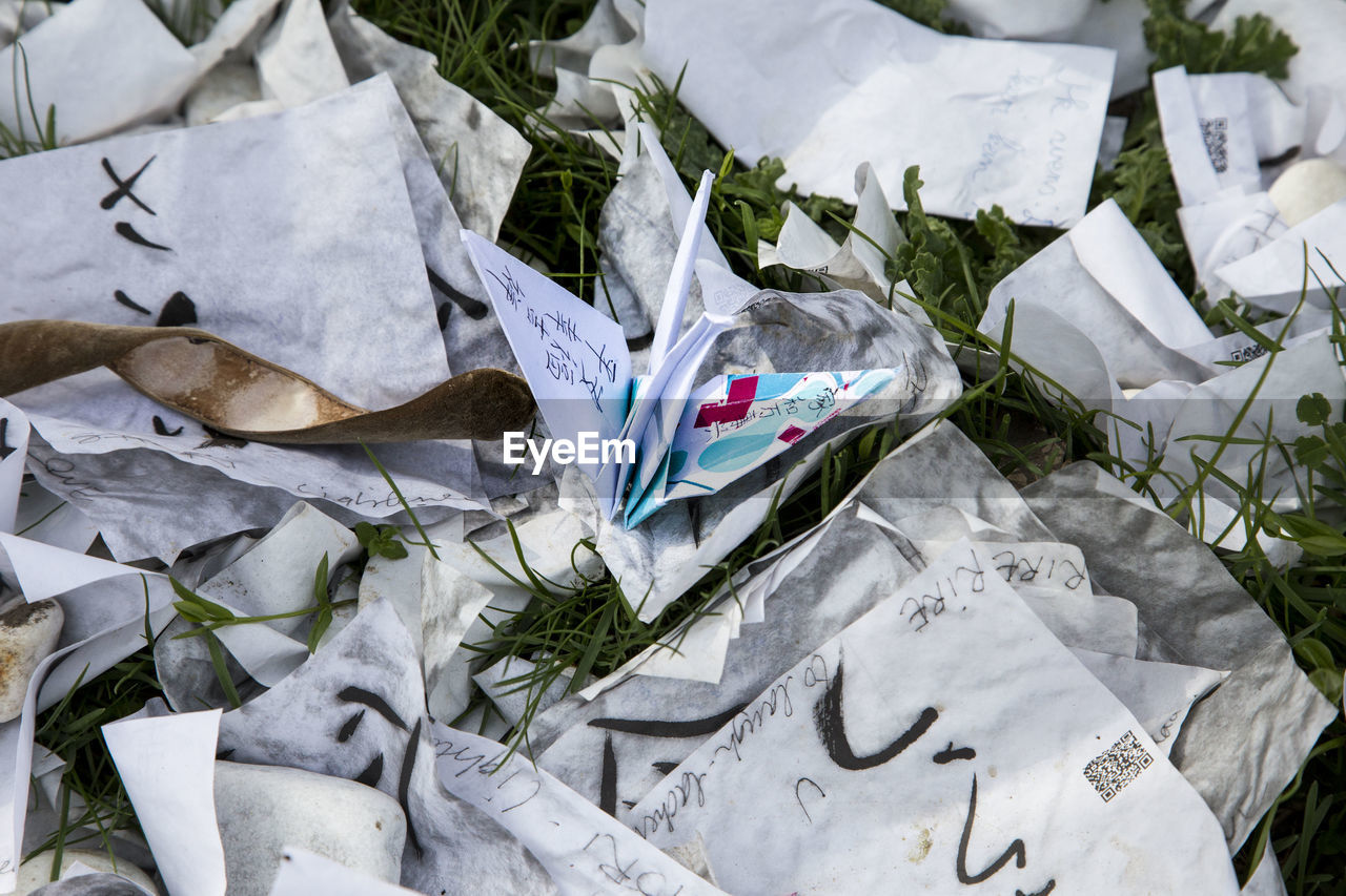 High angle view of paper crane amidst documents on field