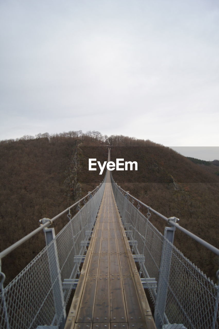 Empty footbridge against sky