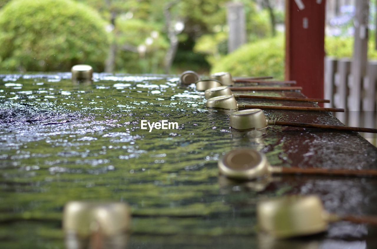 Close-up side view of ladles in water