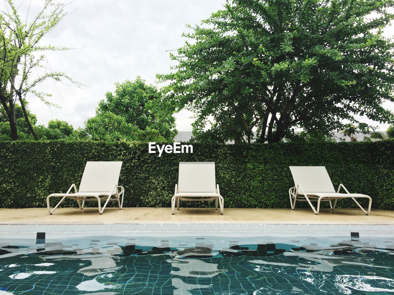 CHAIRS AND SWIMMING POOL IN PARK