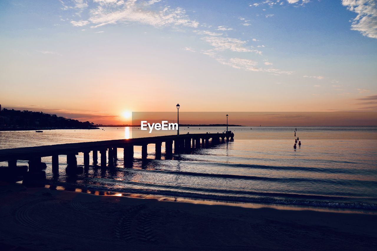 SCENIC VIEW OF SEA AGAINST SKY AT SUNSET