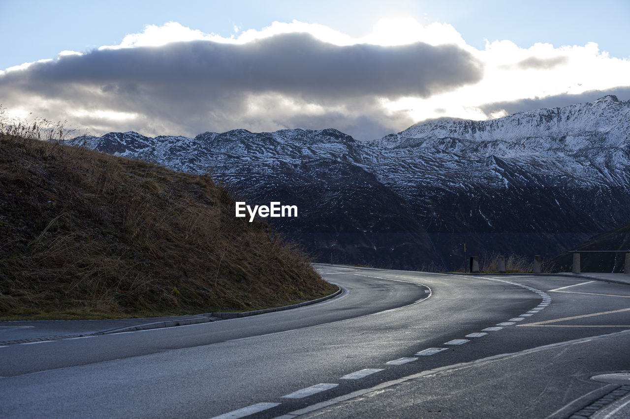 ROAD BY SNOWCAPPED MOUNTAIN AGAINST SKY