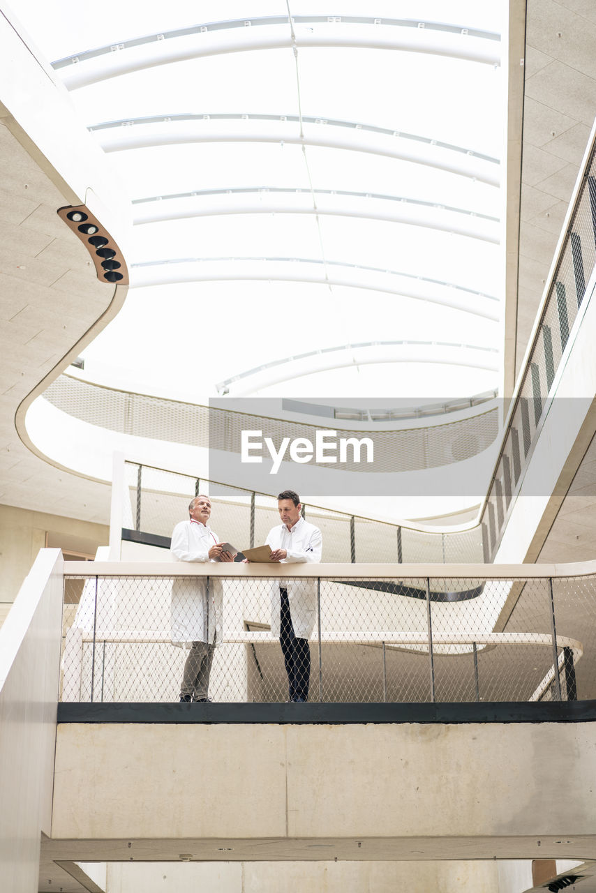 Doctors standing near railing in hospital corridor