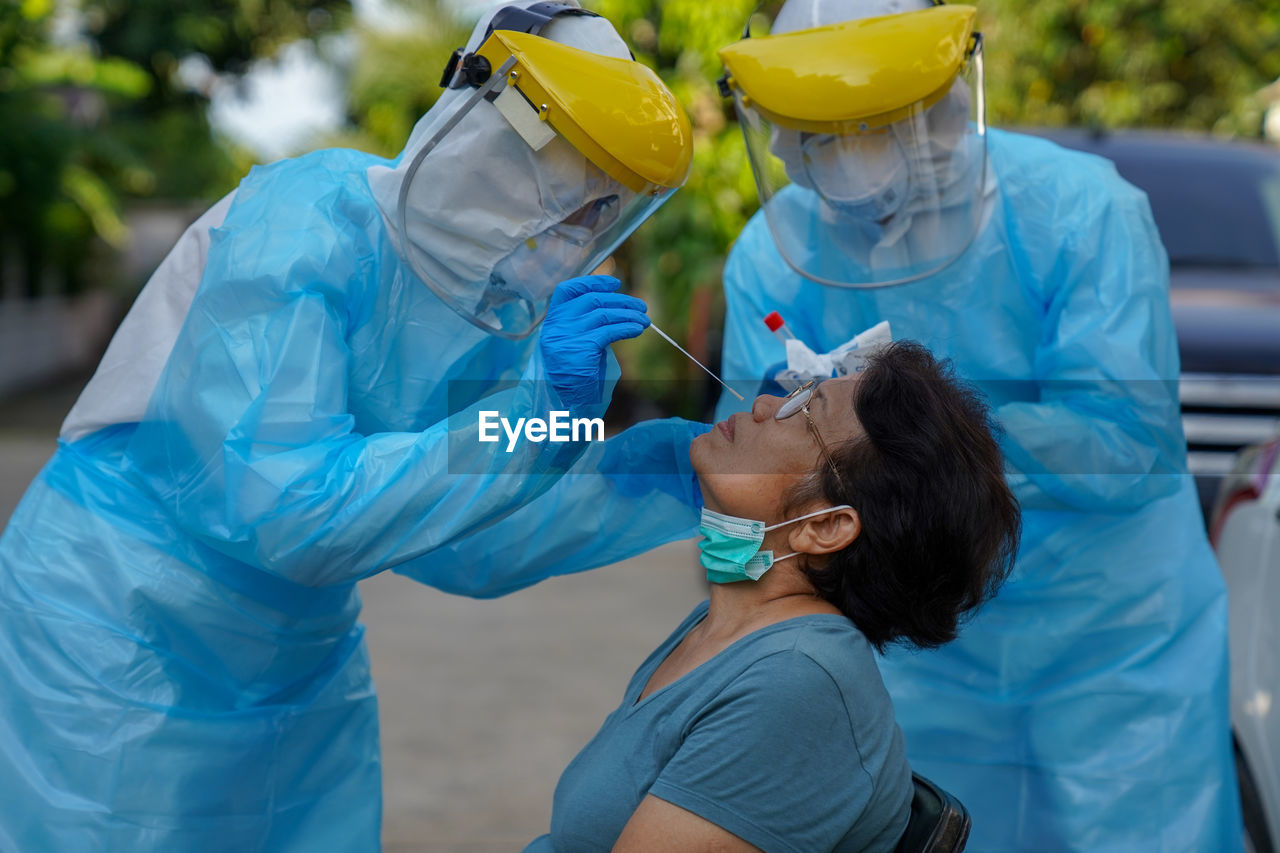 Doctor or nurse wearing ppe n95 mask face shield and personal car road screening for covid-19 virus