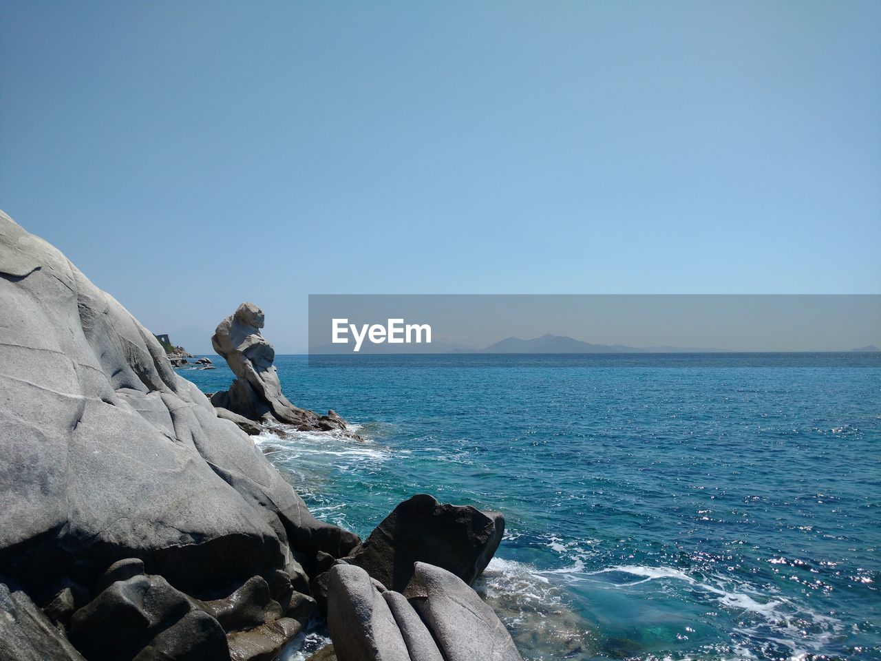 Scenic view of sea and rock formations against clear sky