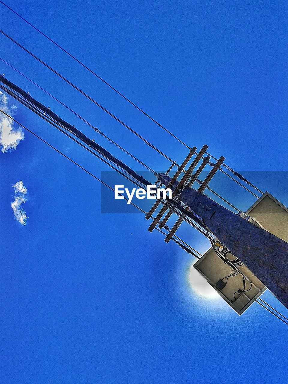 LOW ANGLE VIEW OF POWER LINES AGAINST BLUE SKY