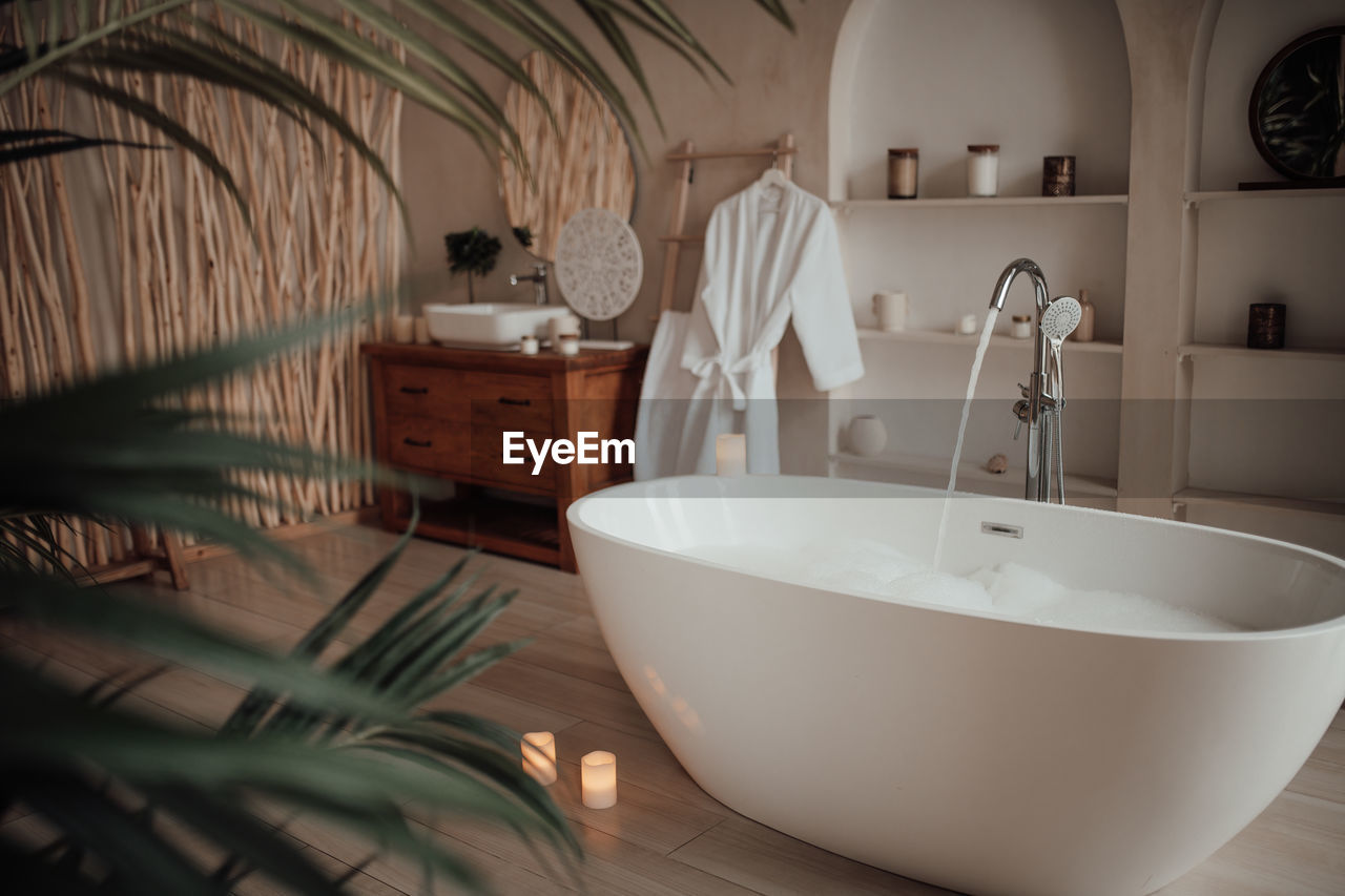 home, domestic room, indoors, bathtub, domestic bathroom, bathroom, room, luxury, household equipment, home interior, wealth, sink, no people, faucet, hygiene, interior design, home showcase interior, plumbing fixture, tap, lifestyles, architecture, furniture, mirror, nature, wood, elegance, flooring, domestic life, white, bidet, house, towel