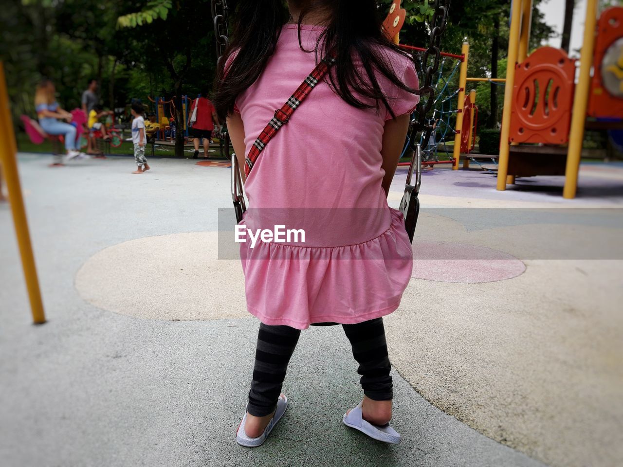 REAR VIEW OF WOMAN STANDING BY STREET