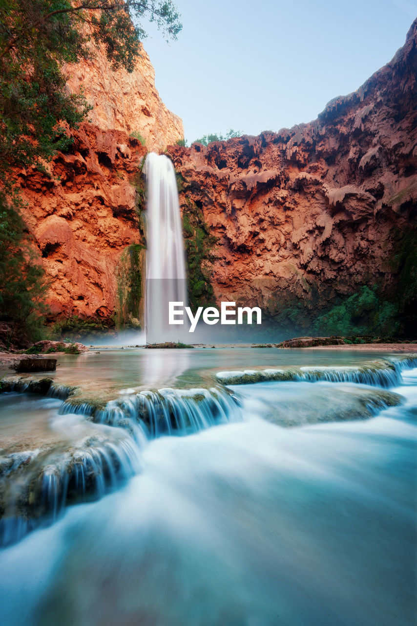 Scenic view of waterfall against sky