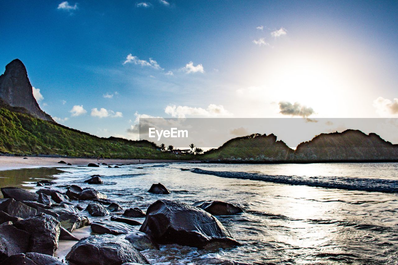 SCENIC VIEW OF ROCKS ON BEACH AGAINST SKY