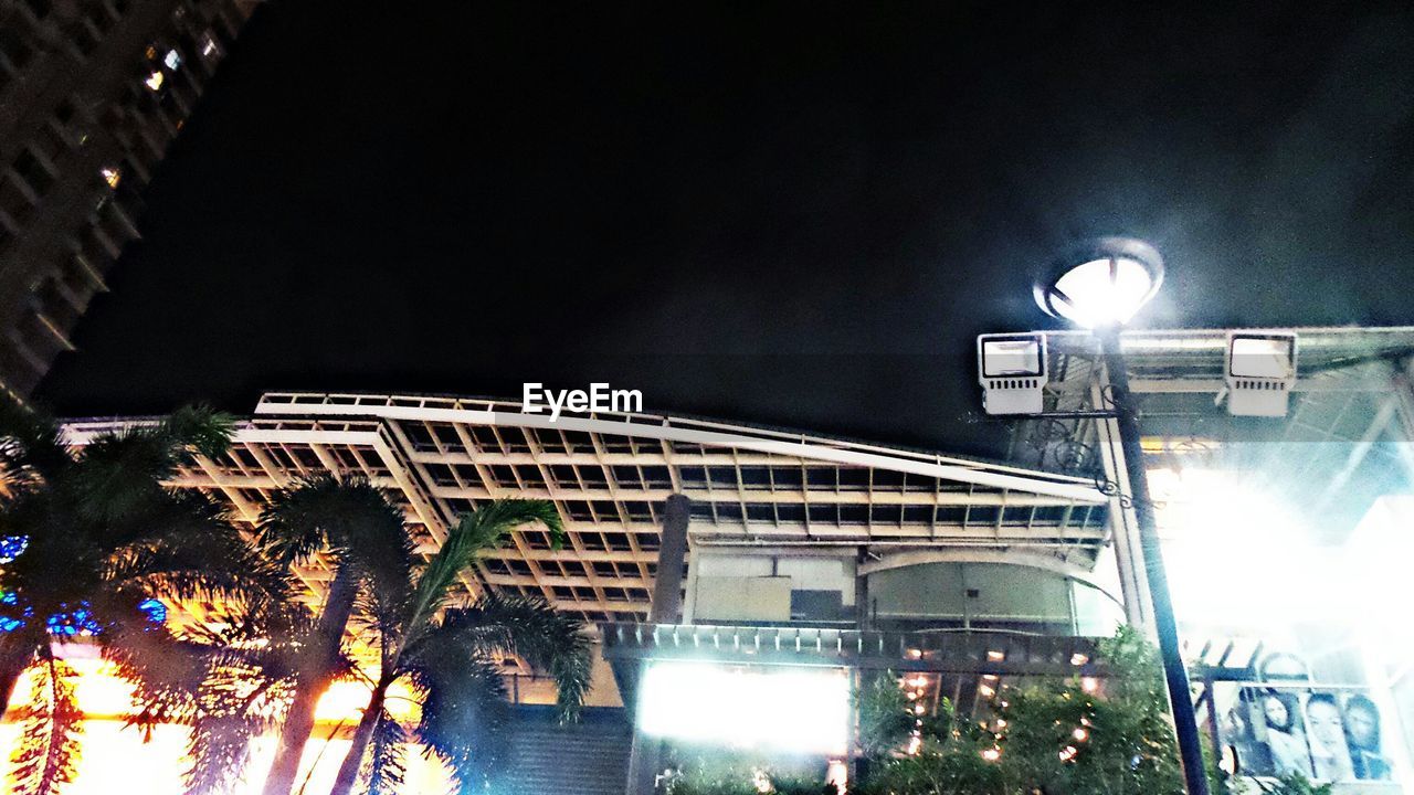 LOW ANGLE VIEW OF ILLUMINATED STREET LIGHTS IN THE DARK