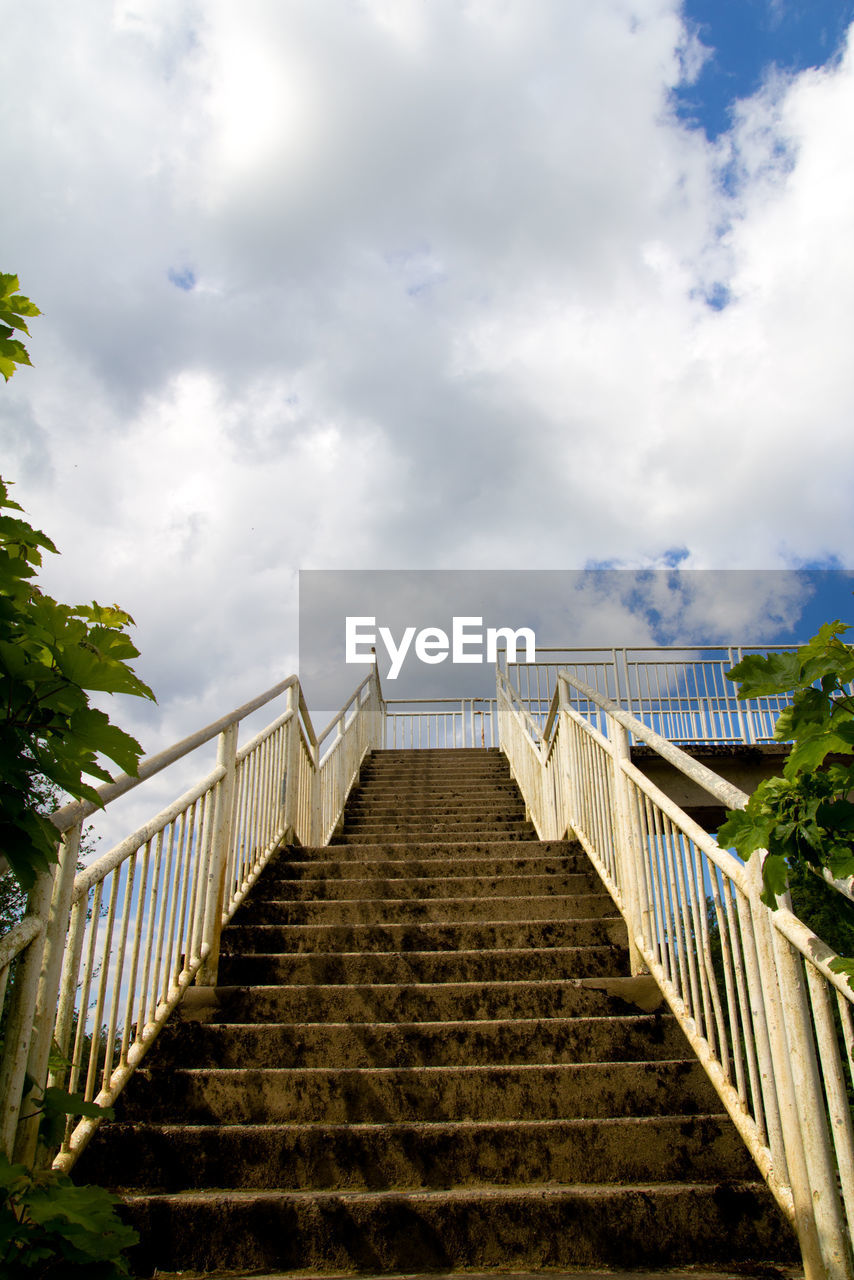 Low angle view of stairs against cloudy sky