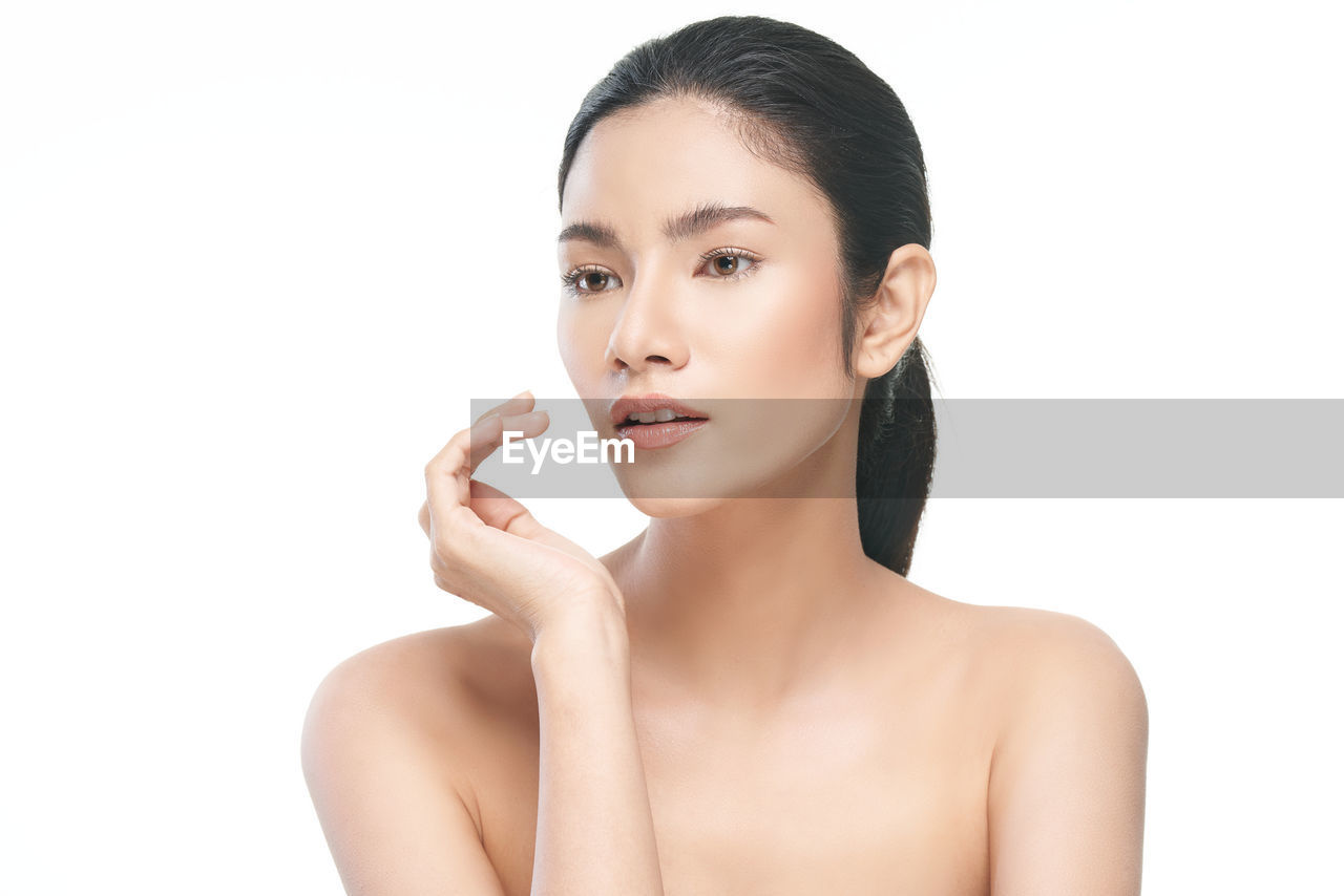 Close-up shirtless young woman against white background