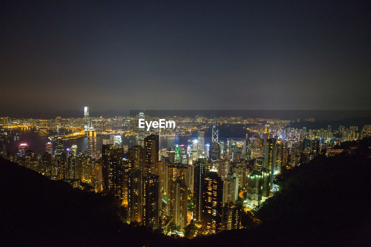 Illuminated buildings in city against sky at night