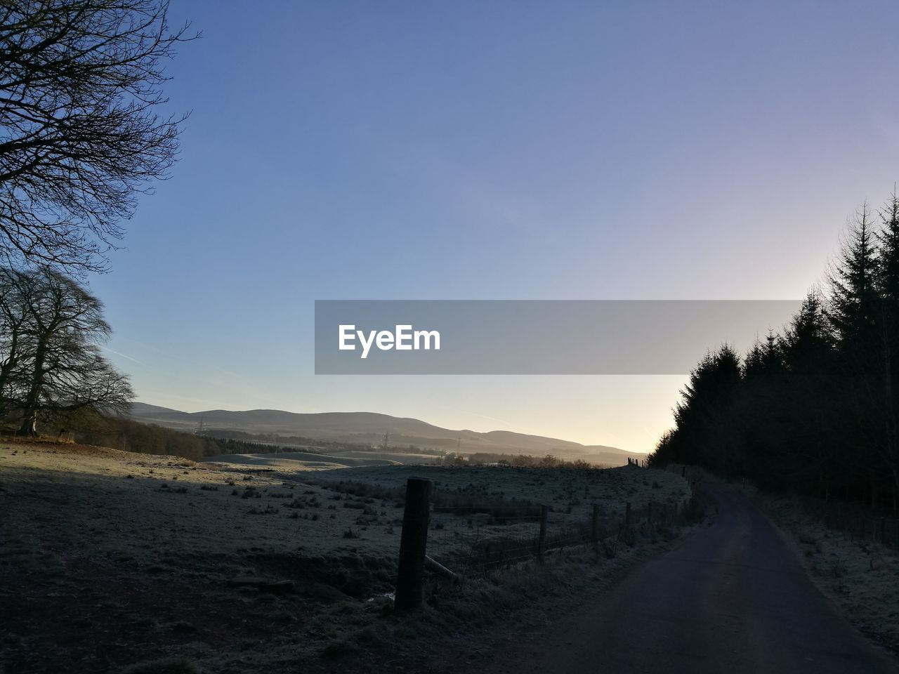 Road by landscape against clear sky