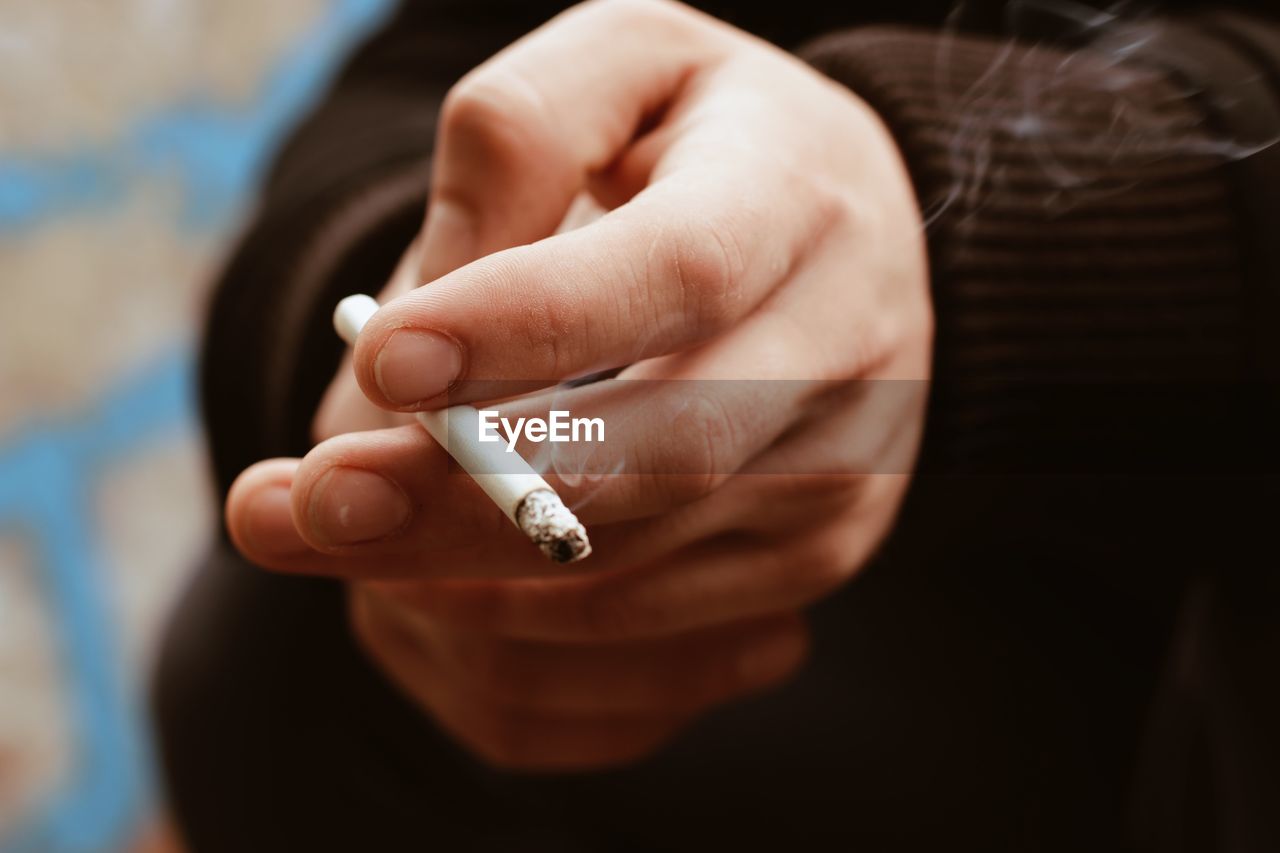 Close-up of person holding cigarette