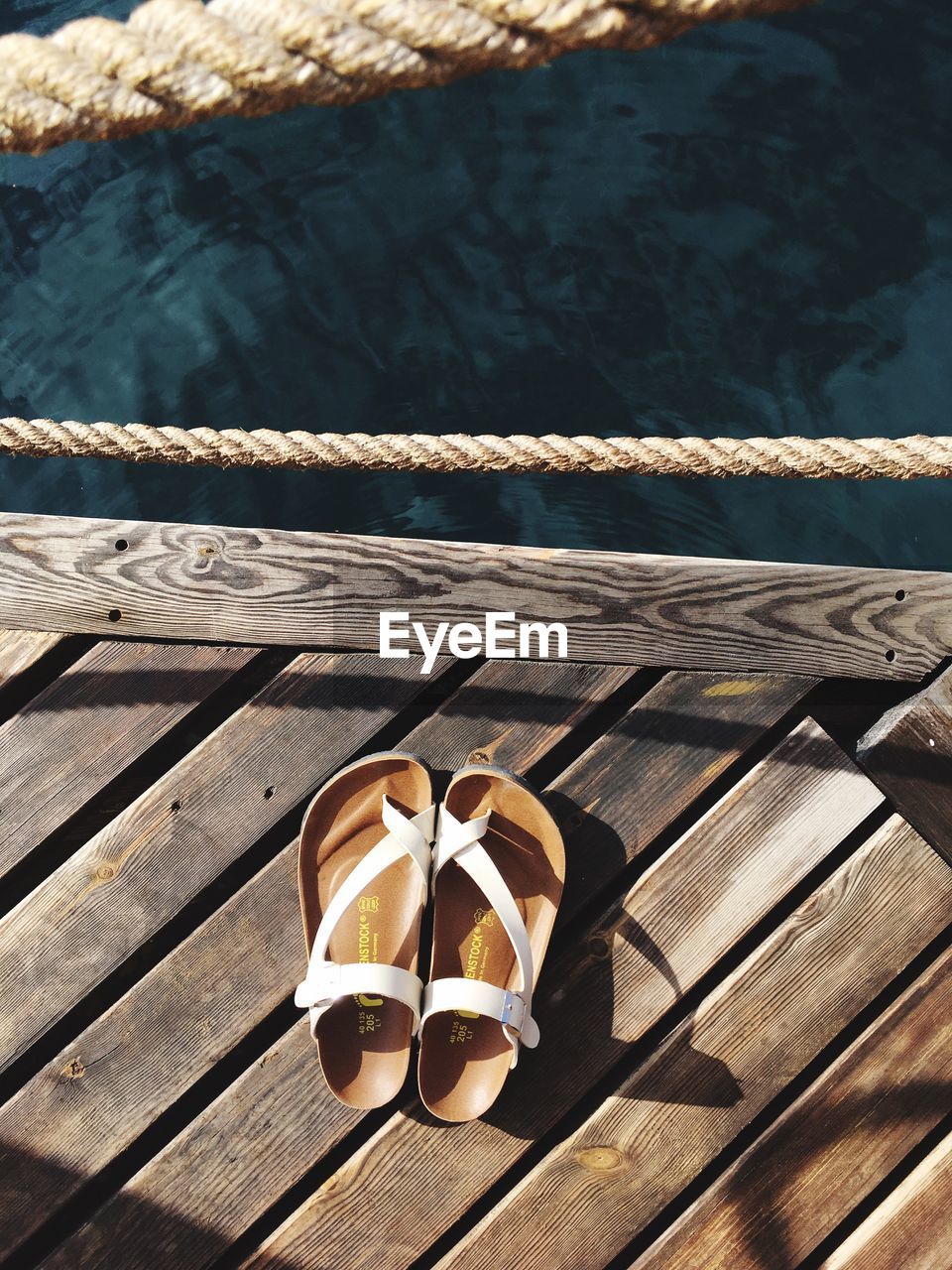 HIGH ANGLE VIEW OF SHOES ON BOARDWALK