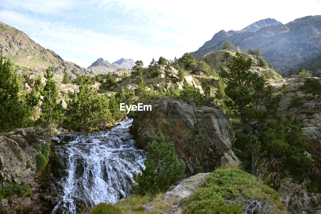 Scenic view of river amidst mountains against sky